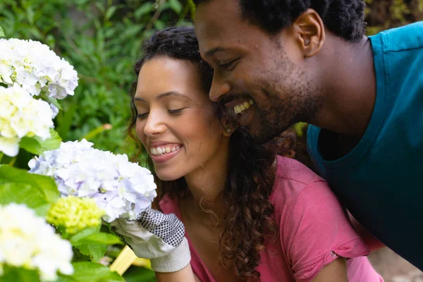 裏庭で新鮮な花の束を嗅ぐ若い出産のカップルを笑顔 人々自然と共同体の概念を変えずに — ストック写真