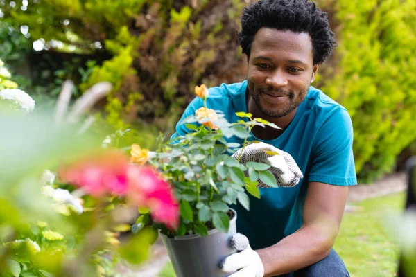 Giovane Afroamericano Sorridente Che Tiene Una Pianta Vaso Mentre Giardinaggio — Foto Stock