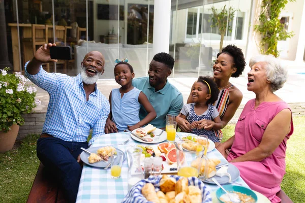 Uomo Anziano Afroamericano Sorridente Mentre Prende Selfie Con Famiglia Tavola — Foto Stock