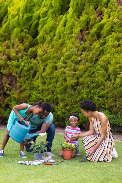 Full Längd Glada Afrikanska Familjen Vattna Växter Tillsammans Trädgården Trädgård — Stockfoto