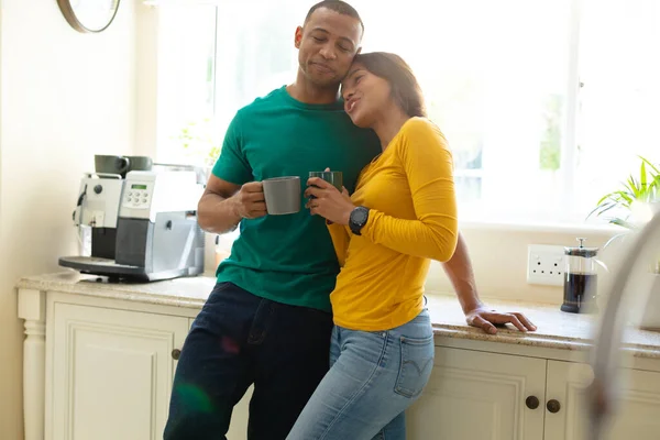 Романтична Молода Афроамериканська Пара Спирається Кухонний Столик Тримаючи Чашки Кави — стокове фото