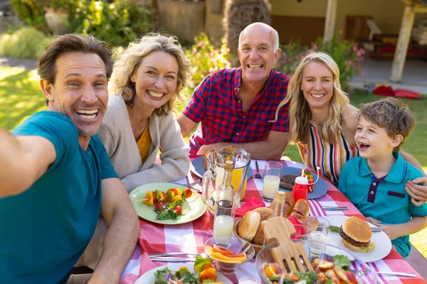 一个快乐的高加索家庭在花园里的餐桌前自拍的画像 聚会和周末生活方式概念 — 图库照片