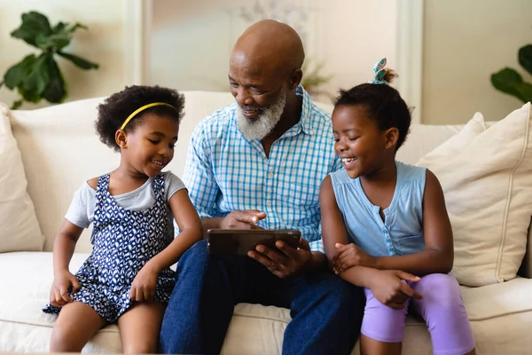 笑非洲裔美国女孩与非洲裔美国祖父展示数字平板 无线技术 生活方式 休闲活动及家庭生活概念 — 图库照片