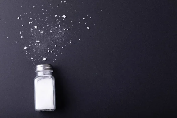 Direkt Ovanför Skott Salt Shaker Och Fallit Salt Svart Bord — Stockfoto