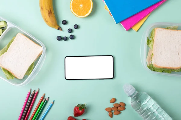 智能手机的头顶视图 屏幕空白 周围有绿色背景的食物和文具 采购产品原汁原味 复制空间 健康食品 无线技术 艺术和包装午餐 — 图库照片
