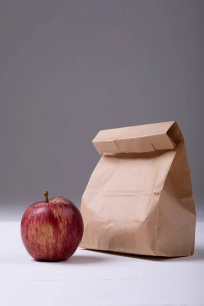 Jabłko Papierowy Worek Obiadowy Stole Szarym Tle Przestrzenią Kopiowania Niezmieniona — Zdjęcie stockowe