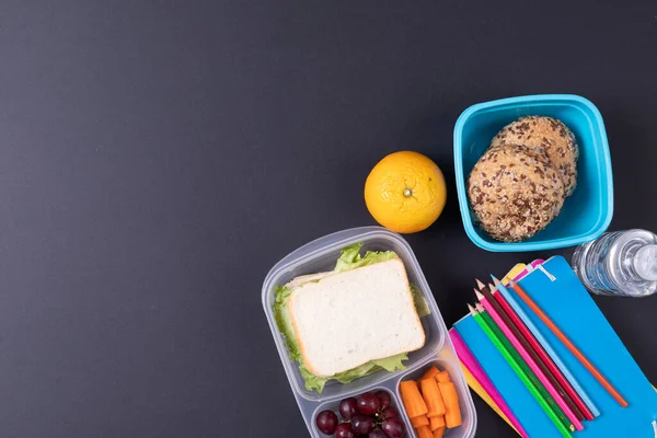 Siyah Arka Planda Okul Malzemeleriyle Dolu Sağlıklı Yemek Yemek Karesinin — Stok fotoğraf