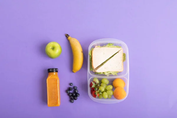 新鲜水果和果汁瓶三明治在松饼盒紫色背景与复制空间 采购产品未经改动 复制空间 健康食品 水果和包装午餐 — 图库照片