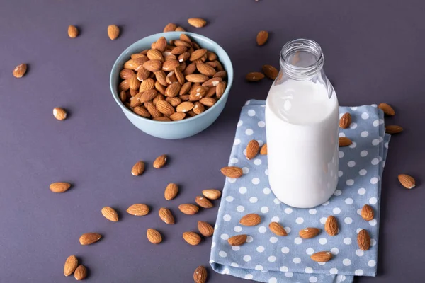 Hög Vinkel Syn Mjölkflaska Med Näringsrika Mandlar Skål Över Grå — Stockfoto