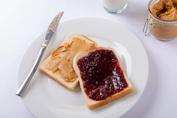 Nahaufnahme Von Erdnussbutter Und Marmelade Auf Brotscheiben Teller Mit Tischmesser — Stockfoto