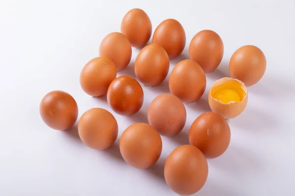 テーブルの上に正方形に配置された1つの壊れた卵と茶色の卵の高い角度ビュー 変わらない健康食品生食有機タンパク生卵黄身静物 — ストック写真