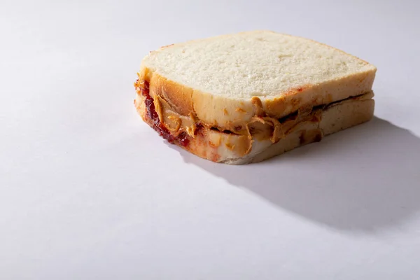 花生酱和果冻三明治的特写 白色背景 空白空间 采购产品原汁原味 花生酱和果冻三明治 健康的食物 复制空间 面包和早餐 — 图库照片