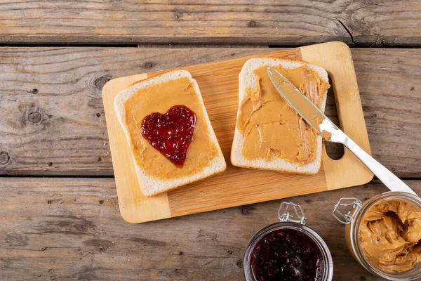 オープンフェイスのピーナッツバターとゼリーサンドイッチのクローズアップは テーブルの瓶でボードを提供しています 変更なしピーナッツバターとゼリーサンドイッチ健康食品テーブルナイフ準備と朝食 — ストック写真