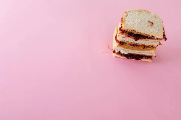 Vista Alto Ângulo Manteiga Amendoim Empilhada Sanduíches Geléia Fundo Rosa — Fotografia de Stock
