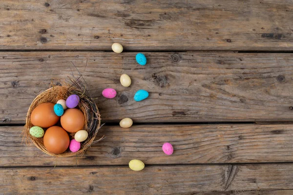 Bezpośrednio Nad Strzał Wielkanocny Jajko Kolorowy Cukierek Gniazdo Drewniany Stół — Zdjęcie stockowe