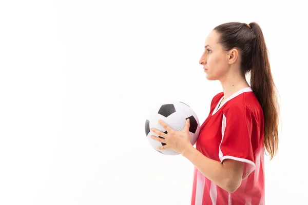 白地を背景にサッカーボールを持つ白人の若い女性選手の側面図 変更されていない スポーツ スポーツの制服 コピースペース 選手や女性のサッカー — ストック写真