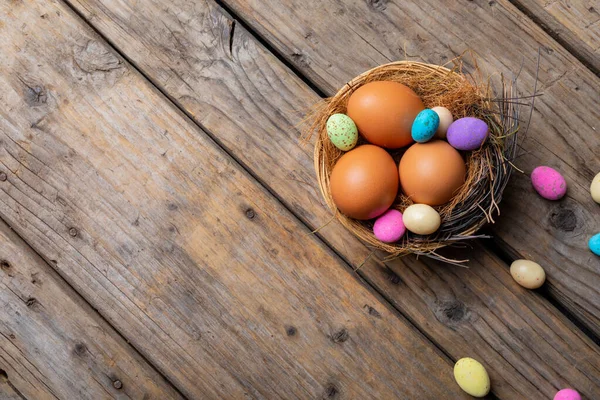 Primer Plano Huevos Pascua Dulces Colores Nido Mesa Madera Inalterado — Foto de Stock