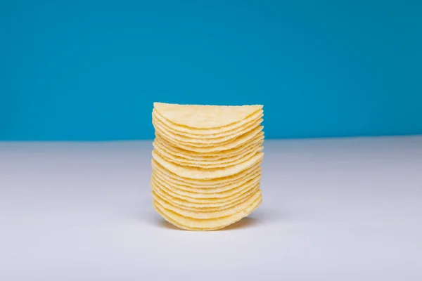 Großaufnahme Gestapelter Kartoffelchips Auf Dem Tisch Vor Blauem Hintergrund Mit — Stockfoto