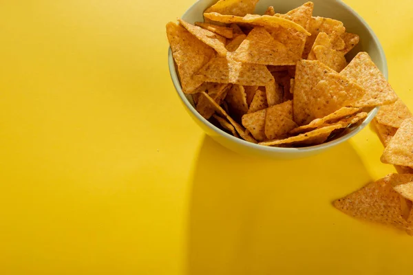 玉米片在碗中的黄色背景与复制空间 不变的 不健康的食物 零食和脆饼干 — 图库照片