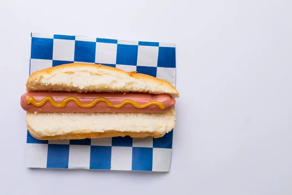 Bezpośrednio Nad Ujęcie Hot Doga Sosem Musztardowym Sprawdzonym Papierze Wzór — Zdjęcie stockowe