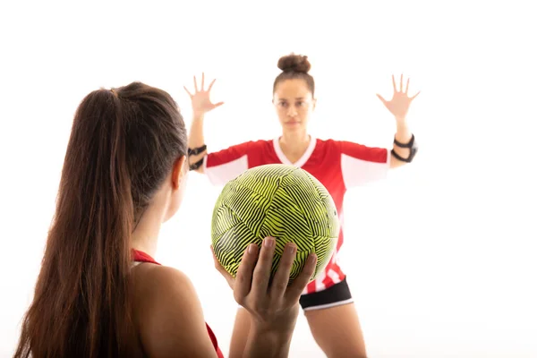 白人と生まれたばかりの若い女性のハンドボール選手は白い背景を背景にボールで遊んでいる 変更されていない スポーツ スポーツユニフォーム ライバル チームハンドボール — ストック写真