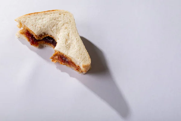 高角度的花生酱和果冻三明治 白色背景上缺少咬痕 采购产品原汁原味 花生酱和果冻三明治 健康的食物 复制空间 面包和早餐 — 图库照片