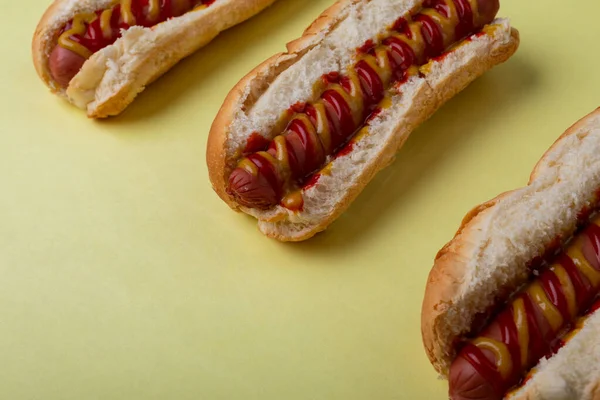 High Angle View Sausages Arranged Row Yellow Background Unaltered Unhealthy — Stock Photo, Image