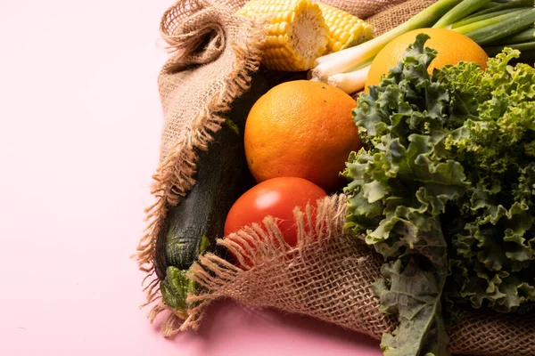 ケール ズッキーニ コーンをピンクの背景に重ね合わせます 変化のない健康的な食べ物野菜生の食べ物果物有機的な概念 — ストック写真