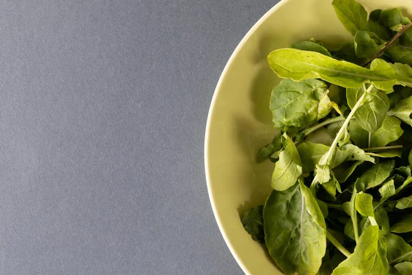 就在正上方的一碗叶子蔬菜在桌子上与复制空间的镜头 生食及有机食品概念 — 图库照片