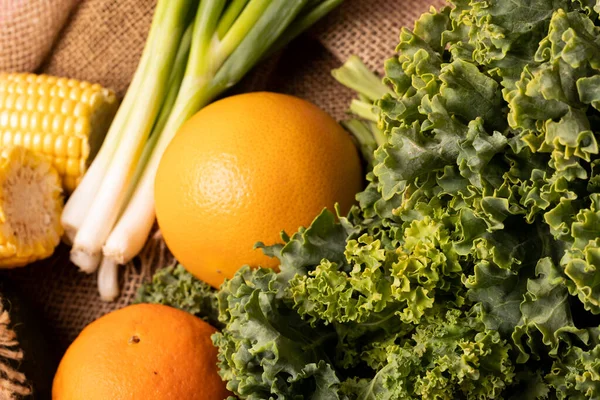 ケールの高い角度のクローズアップ ねぎとトウモロコシとオレンジ 変化のない健康的な食べ物野菜生の食べ物果物有機的な概念 — ストック写真