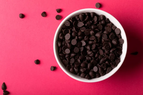 Bovenaanzicht Van Verse Chocoladechips Schaal Roze Achtergrond Ongewijzigd Zoet Ongezond — Stockfoto
