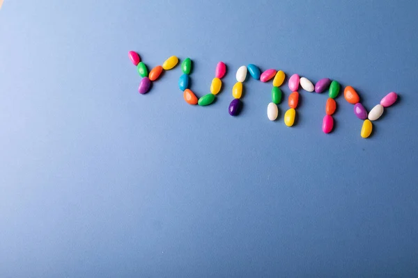 Fotokopi Alanı Üzerinde Mavi Arkaplandaki Renkli Şekerlerden Ayarlanmış Lezzetli Kelimelerin — Stok fotoğraf