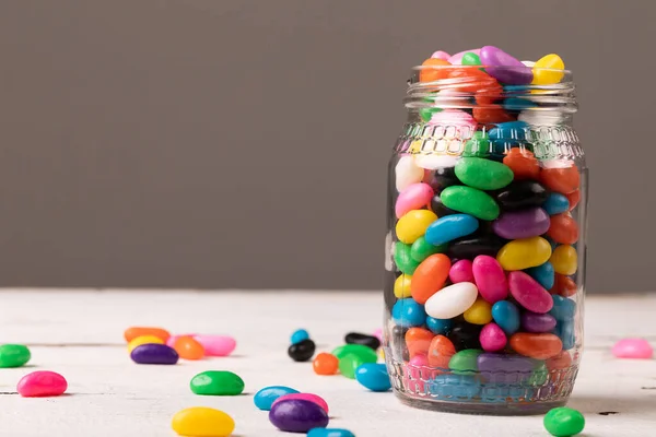 Nahaufnahme Eines Vollen Glasgefäßes Mit Bunten Bonbons Vor Grauem Hintergrund — Stockfoto