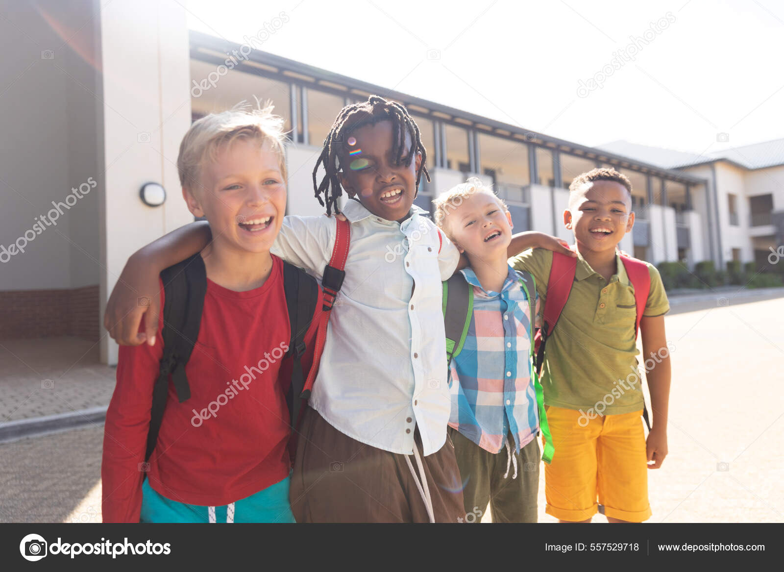 Happy Multiracial Elementary Schoolboys Arm Standing School Campus