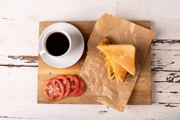 ボード上のトマトスライスとブラックコーヒーと新鮮なチーズサンドイッチのオーバーヘッドビュー 変化のない食べ物不健康な食事や軽食の概念 — ストック写真