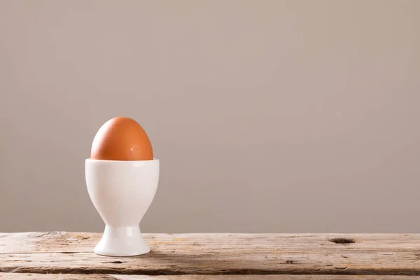 コピースペースと灰色の背景に木製のテーブルの上に白いカップにゆで卵のクローズアップ 変化のない食品健康的な食生活有機的な概念 — ストック写真