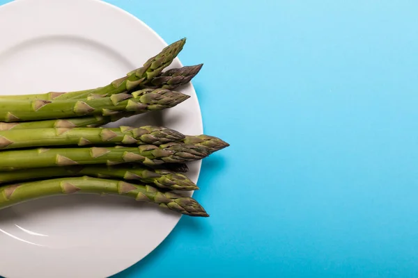 Overhead View Raw Asparagus White Plate Copy Space Blue Background — Stock Photo, Image