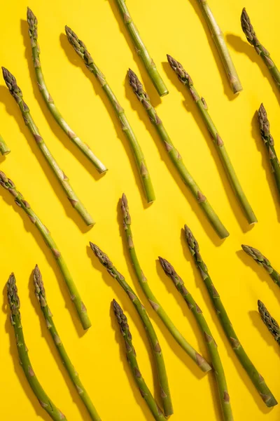 Overhead View Scattered Raw Green Asparagus Yellow Background Unaltered Food — Stock Photo, Image