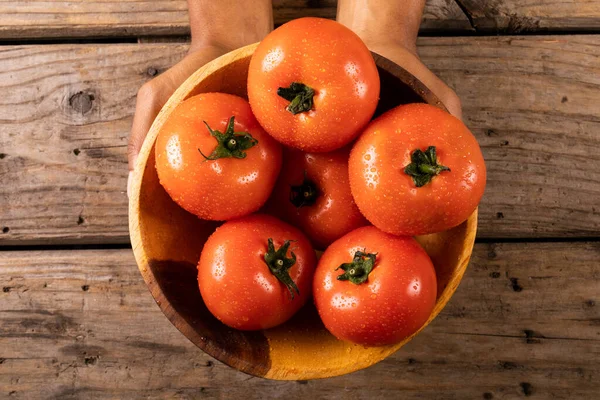 将一碗新鲜的西红柿放在木制桌子上 双手被割破 有机食品与健康饮食概念 — 图库照片