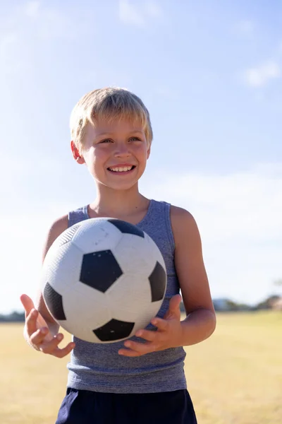 Glimlachende Blanke Basisschooljongen Met Voetbal Die Wegkijkt Terwijl Hij Tegen — Stockfoto