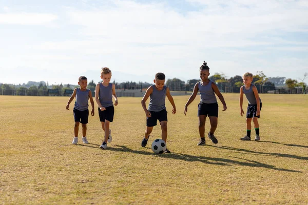 Estudantes Primários Multirraciais Jogando Futebol Campo Futebol Escola Contra Céu — Fotografia de Stock