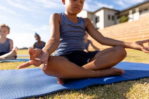 Biracial Elementaire Schooljongen Gebaren Tijdens Het Mediteren Trainingsmat Tijdens Zonnige — Stockfoto