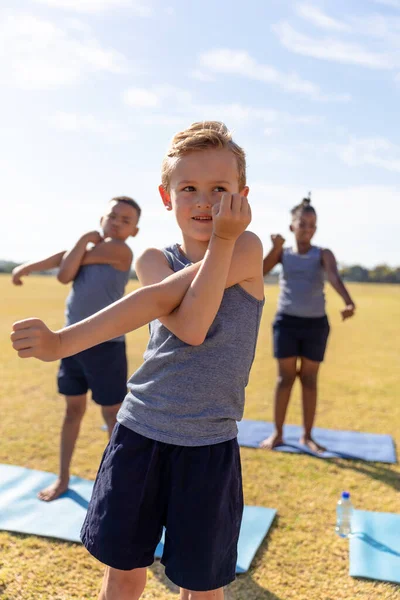 Multiracial Elementary Schoolboys Doing Stretching Exercise While Standing Yoga Mat — Stock Photo, Image