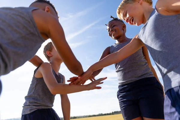 Lachende Multiraciale Basisschooljongens Stapelen Handen Tijdens Voetbalwedstrijd Tegen Lucht Ongewijzigd — Stockfoto