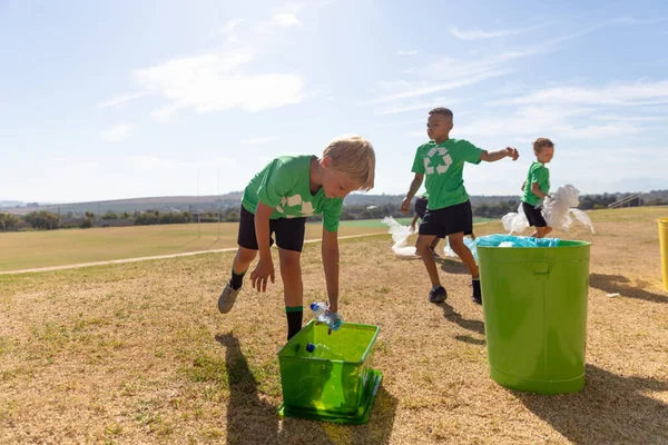 Çok Irklı Ilkokul Öğrencileri Okul Bahçesindeki Çöp Kutusuna Plastik Çöp — Stok fotoğraf