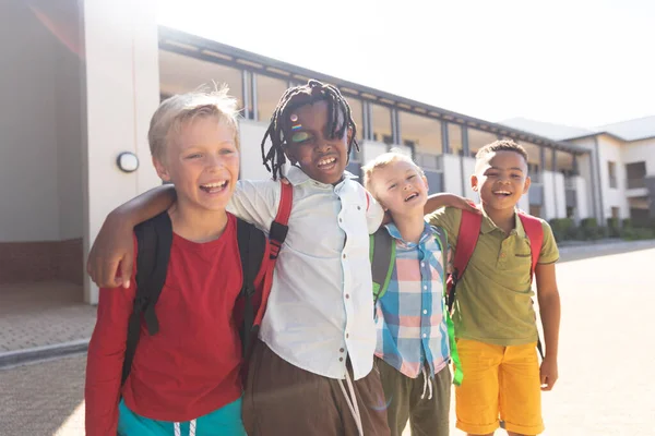 Happy Multiracial Elementary Schoolboys Arm Standing School Campus Sunny Day — Stock Photo, Image