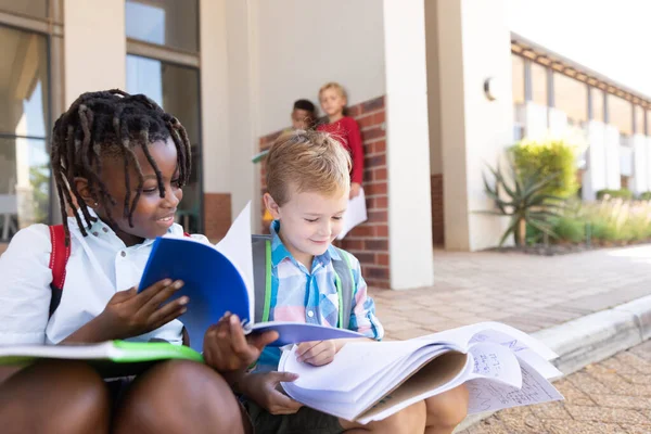 Smiling Multiracial Elementary Schoolboys Studying While Sitting Floor School Entrance — Stock Photo, Image