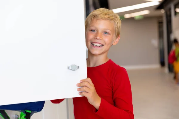 Okuldayken Soyunma Odasının Kapısını Tutan Gülümseyen Beyaz Ilkokul Çocuğunun Portresi — Stok fotoğraf