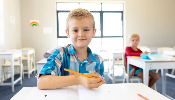 Okulda Masa Başında Oturan Gülümseyen Beyaz Bir Ilkokul Çocuğunun Portresi — Stok fotoğraf