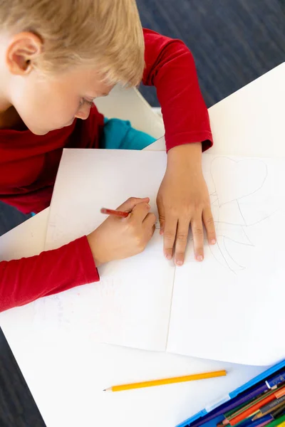 High Angle View Caucasian Elementary Schoolboy Writing Book While Sitting — Stock Photo, Image